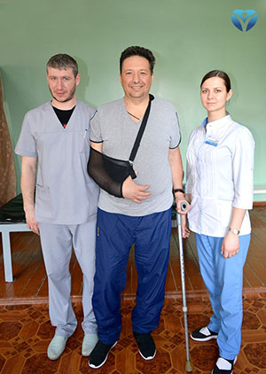 Фото 5 -Пациент после инсульта с специалистами по физичексой реабилитации